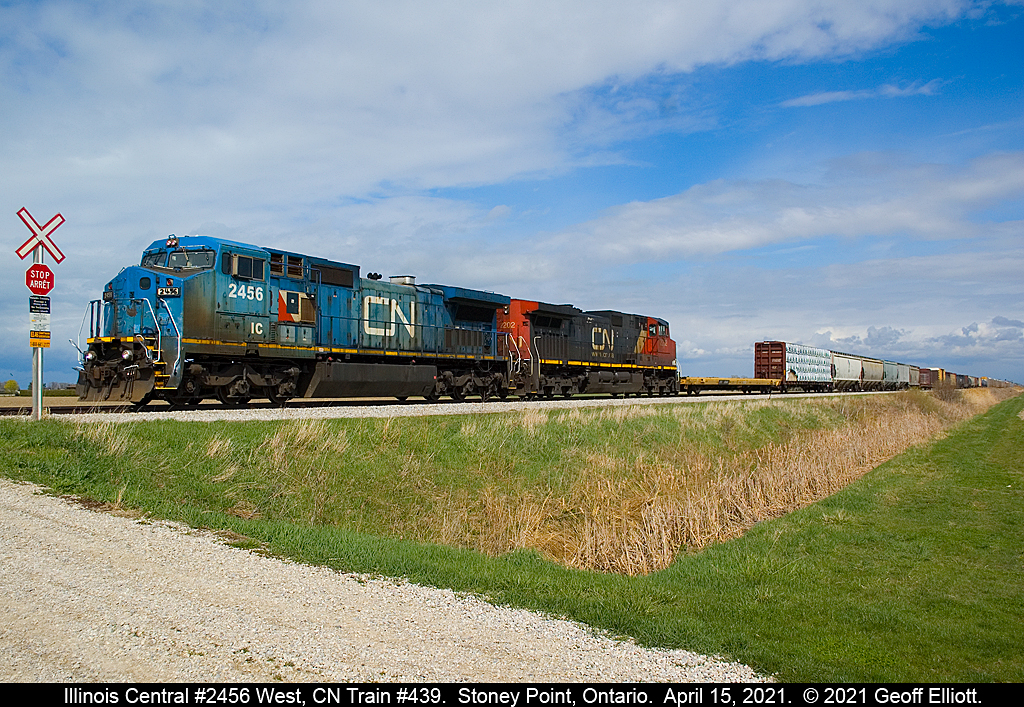 A lot of 'foam' out recently with IC "Blue Devil" #2456 working CN Trains #438/439 since April 8th.  The sun is out, but don't let that fool you as it is pouring rain less than a mile from here and behind me is utter blackness in the sky, but the sun stayed out.  Lucked out today with this shot, as I got 'hosed' on the 13th by an issue with my camera, so the 2nd time is a charm!!  IC 8-40CW #2456 leads today's HUGE train #439 as it is about to cross a private farm crossing at MP 83.46 of the VIA Chatham Subdivision on April 15, 2021.