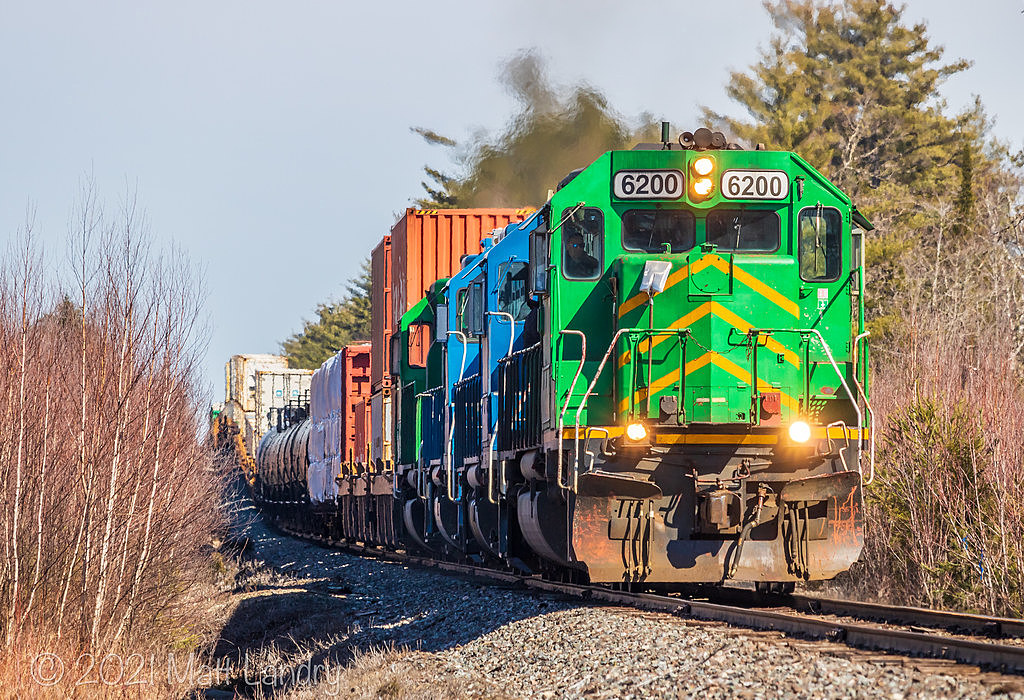 NBSR 6200 leads westbound NBSR train 907 as they descend down the grade at Cork, New Brunswick.