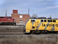 VIA 67 zooms by as what I heard to be CP 118 creeps along on the CP Vaudreuil sub right across the CN Montreal sub. Both GEs meet here at Dorval, Qc.