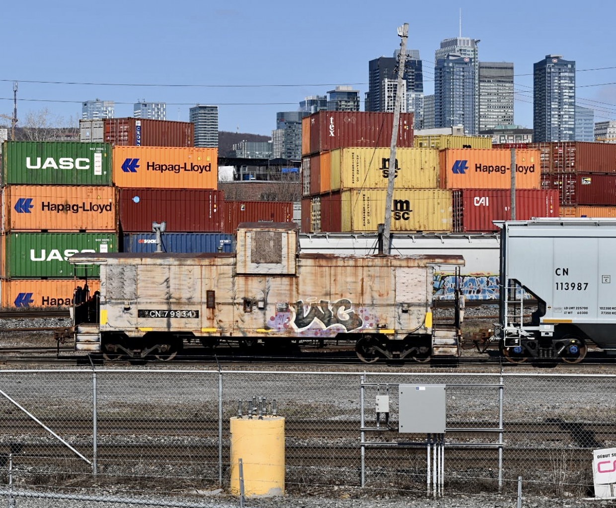 CN L596 heads to the port of Montreal with an old beat up caboose. This is a PSC Caboose, manufactured in the PSC (Pointe-Saint-Charles) shops, so we can say it’s back at home.