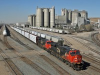 CN A 41251 13 rolls past Bissell Yard and the looming Leigh Cement plant in Edmonton, Alberta.  CN 2964, CN 3090 and mid train remote CN 2971 make easy work of this 178 car train.