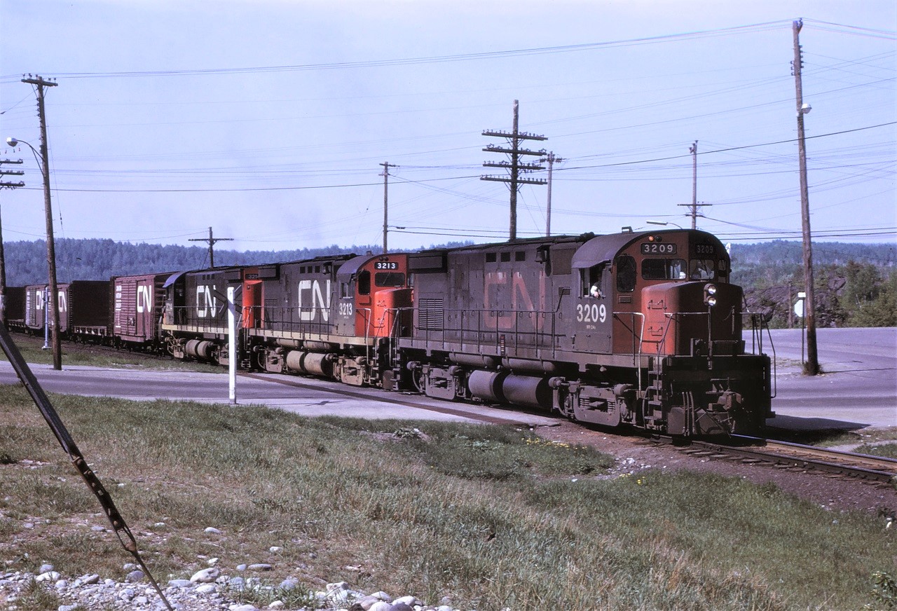 Train 215 with 3 C424s for power is shown arriving in Capreol, Ontario on Saturday, May 28 1972.  This train handled mostly piggyback traffic, but was regularly filled out with other westbound cars.  Units are 3209, 3213, and 3214.  The use of 3 C424s/GP35s/GP40s in any combination was common at this time on priority trains before the GP40-2L(W)s arrived in 1974.