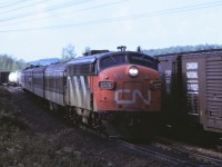 CN's Nakina to Capreol passenger train number 676, slows for its station stop at Laforest, Ontario as a westbound freight pulls through the passing track.  Power for the four car train is FP9A 6526 with steam generator car 15450 bringing up the rear.   