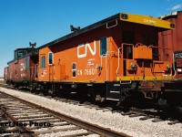 The "S" yard. Located on the other side of the Highway #7 Bridge over CN's MacMillan Yard, in Vaughn during the 90's this area was the location where CN had scrapped anything and everything they had retired or had taken out of active service. “S” was seen chalked on most of the equipment observed on these rusting tracks, which could range from CN cabooses, company MofW cars, vintage Buffalo grain boxcars, retro Car-go-rail boxcars or anything else CN had deemed to be scrapped. The amount of CN owned freight cars scrapped over the years here would no doubt be mind boggling if documented. And in fitting fashion most if not all of this yard is now gone today with hardly a trace remaining as if it never existed. 
<br>
Here on warm and sunny September afternoon CN transfer caboose 76601 and PSC caboose 79479 await their turns with their inevitable demise along with several other cars at the “S” yard.  Note 76601 has “Assigned to Clover Bar” stenciled on its sides, which was likely for Clover Bar, Alberta. It would be interesting to see if anyone out west has any photos of it working that actual area back in the day. 
