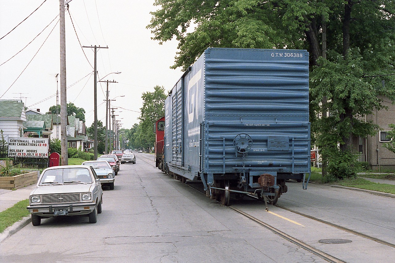 It has been about 7 years since I posted a shot of CN 7724 rumbling down Welland Av in St. Catharines with one car in tow, heading for the GM Plant on Ontario St. ( photo #12027). Well, finally, found a "going" shot of same; and it does look pretty good.
Street running is a rare thing these days.  This view is looking SW on Welland Av, just having crossed over Niagara St intersection. To me, this idyllic street scene appears a lot older than it is.