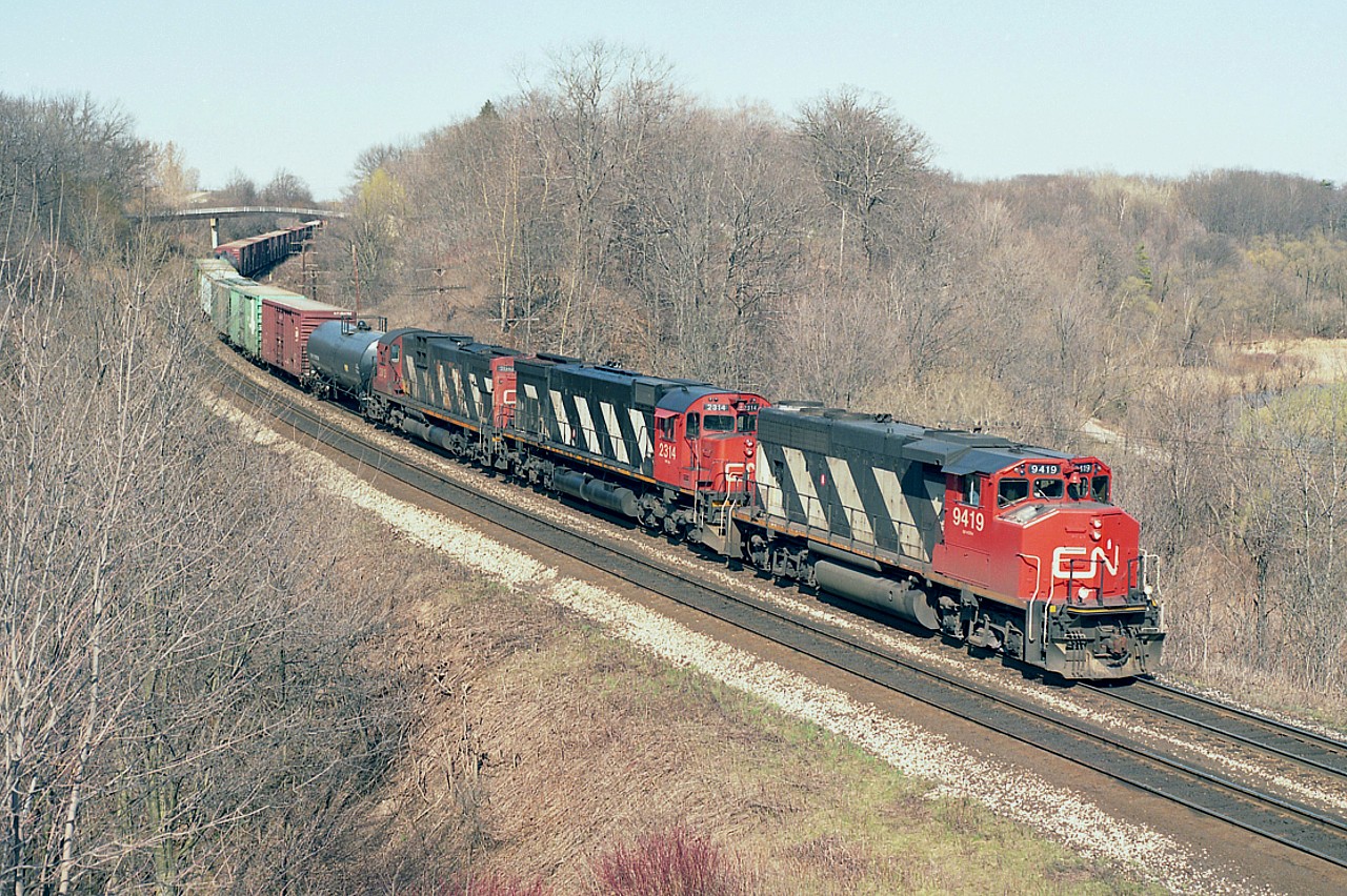 A glimpse back 30 years ago today, April 11, 1991. A beautiful day at Bayview. It was still rather common to see some big MLWs rolling; but we all knew they were on their way out, as not that many were in the lead position any more. Not much green yet, after a typical winter. Average, I'd say. After all, the year 2021 had not much of a winter. Foliage is at least 2 weeks ahead this spring.
As seen from the Plains Rd (former hwy 2) bridge mid-afternoon; CN 9419, 2314 and 2013 rumbles westbound.