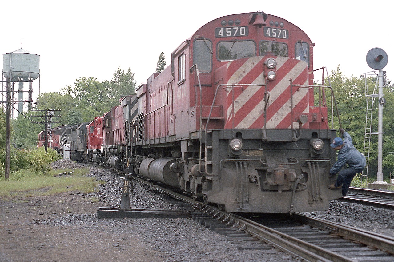 One miserable grey day finds me up in Parry Sound. Thats just the way it goes....and in regards to the weather being a deterrent, as it is said about other things, "When ya gotta go, ya gotta go"........and so with the weather forecast "iffy" I left for The Sound anyway.
Too bad the best seems to be seen on the worst of days......in this image, the train has just set off a cut at Parry Sound's diminutive 'yard' before heading south (east on timetable) and the power is backing onto train for the run  to Toronto.  Seen, from the head end; CP 5519, CR 7793, CP 3073, 4715 and 4570. The old water tower on the hill has since been demolished and the yard is no longer. Trains just run thru. The station, preserved as a private business, is a hundred feet or so behind me on the right.