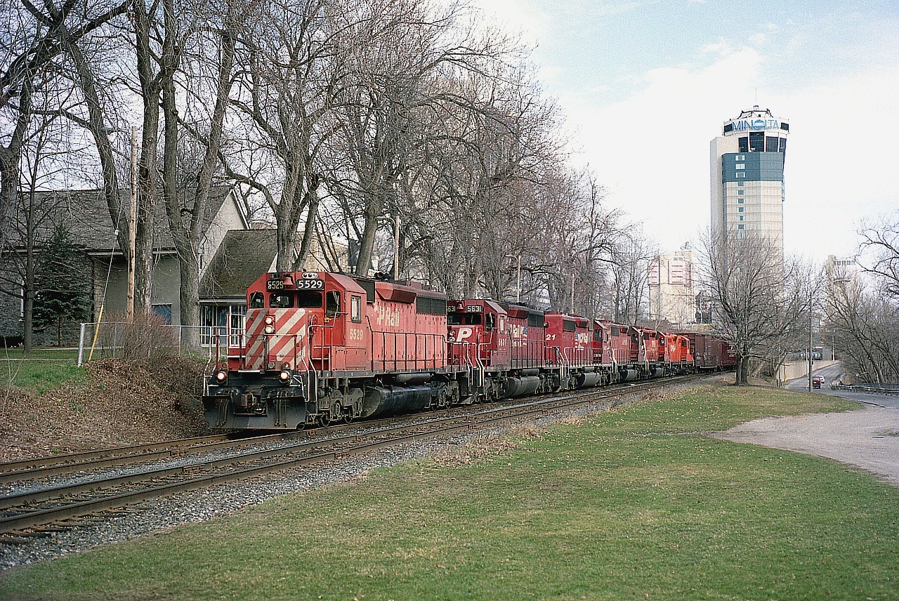 Once again, memories from one of my favourite spots in Niagara. The "South Siding Switch", which now is still in place as Montrose Sub, Chippawa Industrial spur. (The line that used to go thru the Falls area ends here). In this view, CP 5529, 5631, 5421, 5578, 5689 and 8239 head up a train westbound; with Montrose Yard just around the bend behind me... a mile or so.
Times sure have changed. It used to be the Tower that stood out all by its' lonesome. We see the advance of the hotel scene in this image, and I would not be surprised if the tower is now dwarfed and hidden.  Haven't been back lately to check.