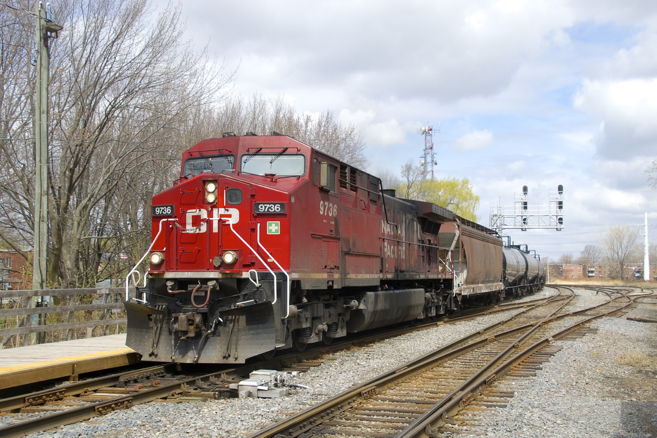 CP 9736 was freshly repainted a couple years ago but is currently quite filthy as it leads ethanol train CP 650 under a signal gantry and past Lasalle Station.