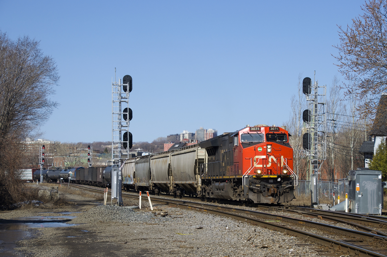 CN X306 with CN 3071 up front and CN 3102 mid-train splits a pair of signals as it approaches MP 3 of CN's Montreal Sub.