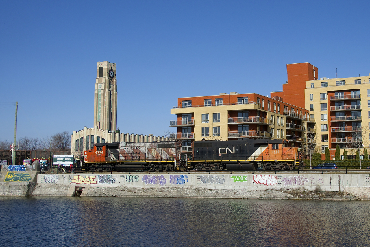 CN 4729 & CN 4774 are heading east light to pick up grain empties at Ardent Mills. At left is the Atwater Market, completed in 1933.