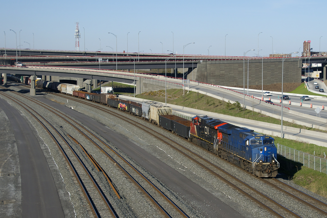 CN 321 has one of the few units on CN that are still in the blue GECX paint scheme, with most of the blue GECX units repainted into CN colours and renumbered. It is seen leading a 96-car CN 321, with CN 3185 trailing on a sunny spring evening. GECX 2029 is supposed to become CN 3121 once it is repainted and renumbered.