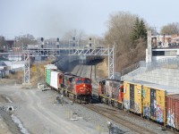 CN 324 is passing CN 500, which is stopped and about to set off some cars on the freight track of CN's Montreal Sub. 