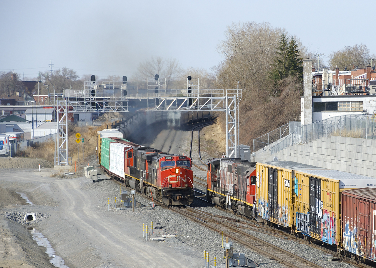 CN 324 is passing CN 500, which is stopped and about to set off some cars on the freight track of CN's Montreal Sub.