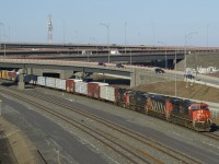 CN 401 emerges from under the Turcot interchange with a varied lashup consisting of CN 2886, CN 2403, BCOL 4654 & CN 4800.