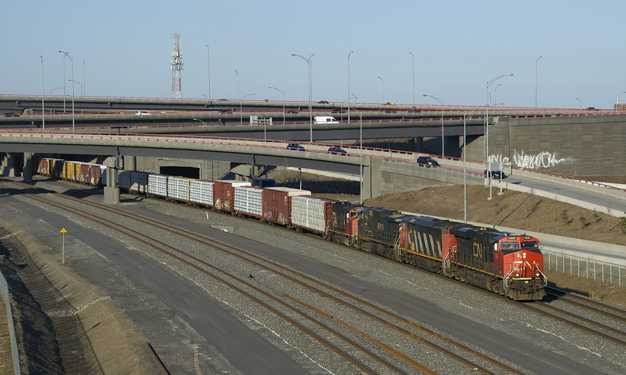CN 401 emerges from under the Turcot interchange with a varied lashup consisting of CN 2886, CN 2403, BCOL 4654 & CN 4800.