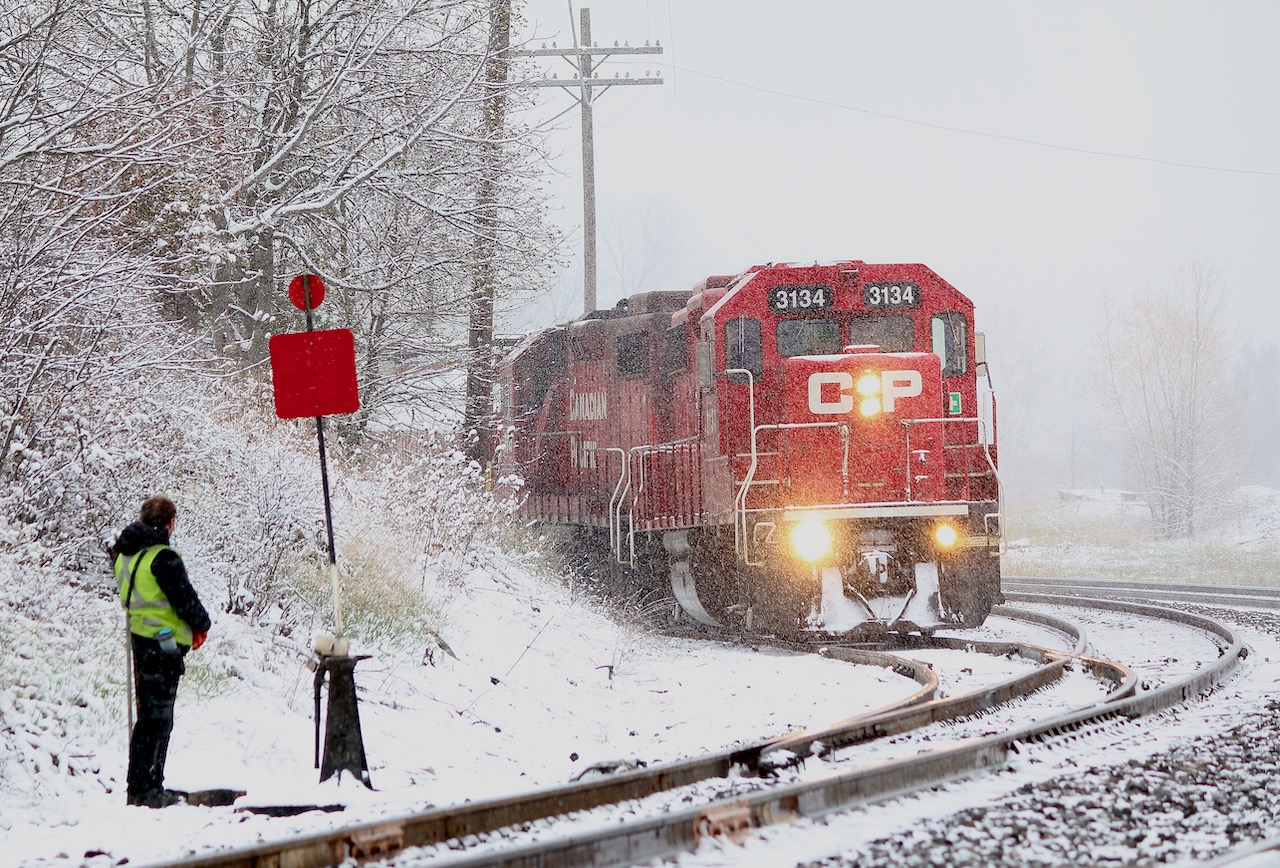 We are definitely well past April fools day but this morning Mother Nature had a bit of a surprise for us. It is kind of nice as far as photography goes getting a change of pace when seasons collide. I'm not straying to far from home these days for obvious reasons so it is nice having at least CP close to home. This morning CP local T14 had some work to do at the Ardent mill in Streetsville before heading for the yard, so it was a good chance to get a few last minute winter shots in. A crew member is waiting at the mainline switch as the two GP38's pull an empty cut of cars out of the elevator before spotting a cut of loaded cars.