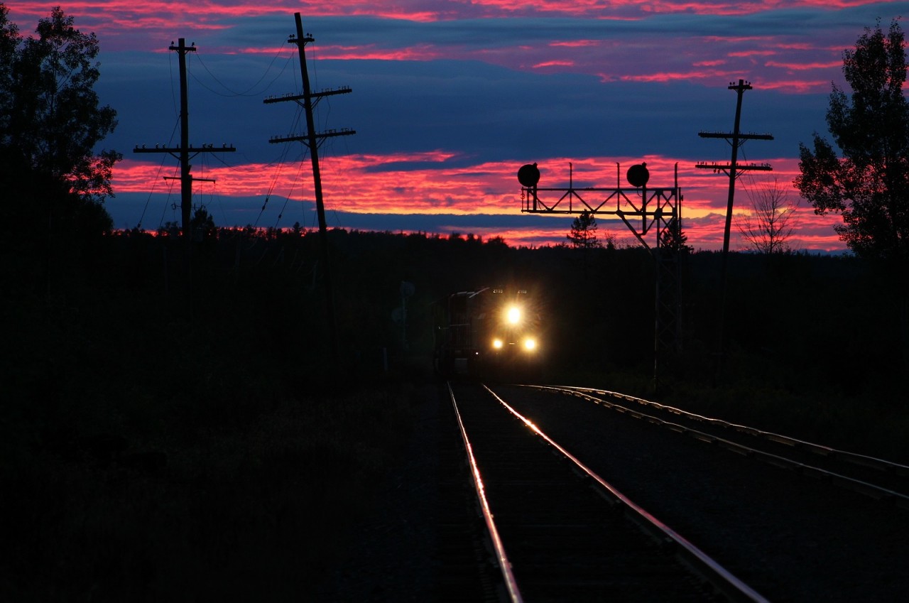 Under the most beautiful sunset I have ever seen, ONR 512 returns to Englehart after working in Rouyn-Noranda, QC. Their train consists of loaded sulfuric acid tanks and empty covered gondolas used for carrying copper "mud".