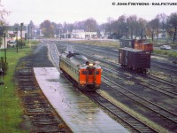 <b>Last CN Passenger service at Palmerston, part 1.</b>  Operating as an extra, formerly running as train number 672 - the southbound RDC-1 passenger car from Owen Sound - coasts into Palmerston on Saturday, October 24, 1970 for the final time. Arriving at 0655h, the Railiner will be moved from the Fergus Sub side of the station over to the Newton Sub side to await the arrival of Extra 6354, formerly train 668 (RDC-2) from Southampton. Both will be combined and having met extra 6118 (RDC-1), the former train 662 from Kincardine, will depart at 0715h for the trip to Toronto (formerly train 658) via the Fergus, Guelph, Halton, and Weston Subs. Extra 6118, which had arrived at 0700h from Kincardine, will too depart at 0715h for Stratford.<br><br>I believe the official last runs of the RDC service to Owen Sound, Kincardine, Southampton, and Goderich was the evening of Fri Oct 23, 1970. Although the Sat runs to Toronto (and Stratford) carried passengers, they were no longer operating as scheduled trains, hence the extra flags. Daylight Saving time ended early Sunday morning, Oct 25, 1979, and CN and CP would bring out their winter timetables at this time change.<br><br>Note <a href=http://www.railpictures.ca/?attachment_id=3218>Canadian National 81 in the distance.</a> The E-10-a mogul, built in 1910 by CLC as GTR 1001, E12 class. Later renumbered CNR 903 in 1923, and finally CNR 81 in 1951. She was donated to the City of Palmerston in 1959 and remains there well taken care of today.<br><br><i>John Freyseng Photo, David Warne Collection slide.</i>