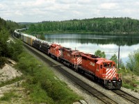 Westbound auto racks train 499 passes Island Lake on the last lap into Kenora Ontario. CP used left hand runnin on itrs double track between Winnipeg and Thunder Bay