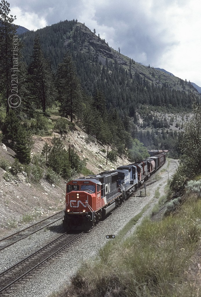 Eastbound CN 5688 with CR 740, CN 5188 and 5102 are at Conrad on CNs Ashcroft Sub. Conrad is just west of the bridges at Cisco.