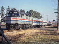 Its been 17 years since the final run of the Amtrak/VIA Toronto – Chicago <i>International</i> on Friday, April 23, 2004.  Here the westbound 685 is seen crossing Mill Street in Baden on the run to Chicago.  At this time the train had been running over the Guelph subdivision for less than a year, having been shifted to the north mainline <a href=http://www.railpictures.ca/?attachment_id=31325>from the Oakville/Dundas subs</a> on January 15, 1990.  F40PH 359 (built Dec. 1980) leads this day’s train made up of mostly Horizon cars plus one Amfleet I coach.  Note the second car wears the narrow stripe phase iii scheme while the others wear the wide stripe phase iii scheme.  While the 359 is long gone from Amtrak’s roster the Horizon and Amfleet cars still make up much of the fleet.<br><br>More Amtrak International on the Guelph Sub:<br><a href=http://www.railpictures.ca/?attachment_id=34478>Stratford, June 16, 2000</a> by Arnold Mooney<br><a href=http://www.railpictures.ca/?attachment_id=29217>Guelph, October 2000</a> by Bill Thomson<br><a href=http://www.railpictures.ca/?attachment_id=24566>Kitchener, April 13, 2004</a> by Steve Host<br><br><i>Peter Raschke Photo, Jacob Patterson Collection slide. </i>