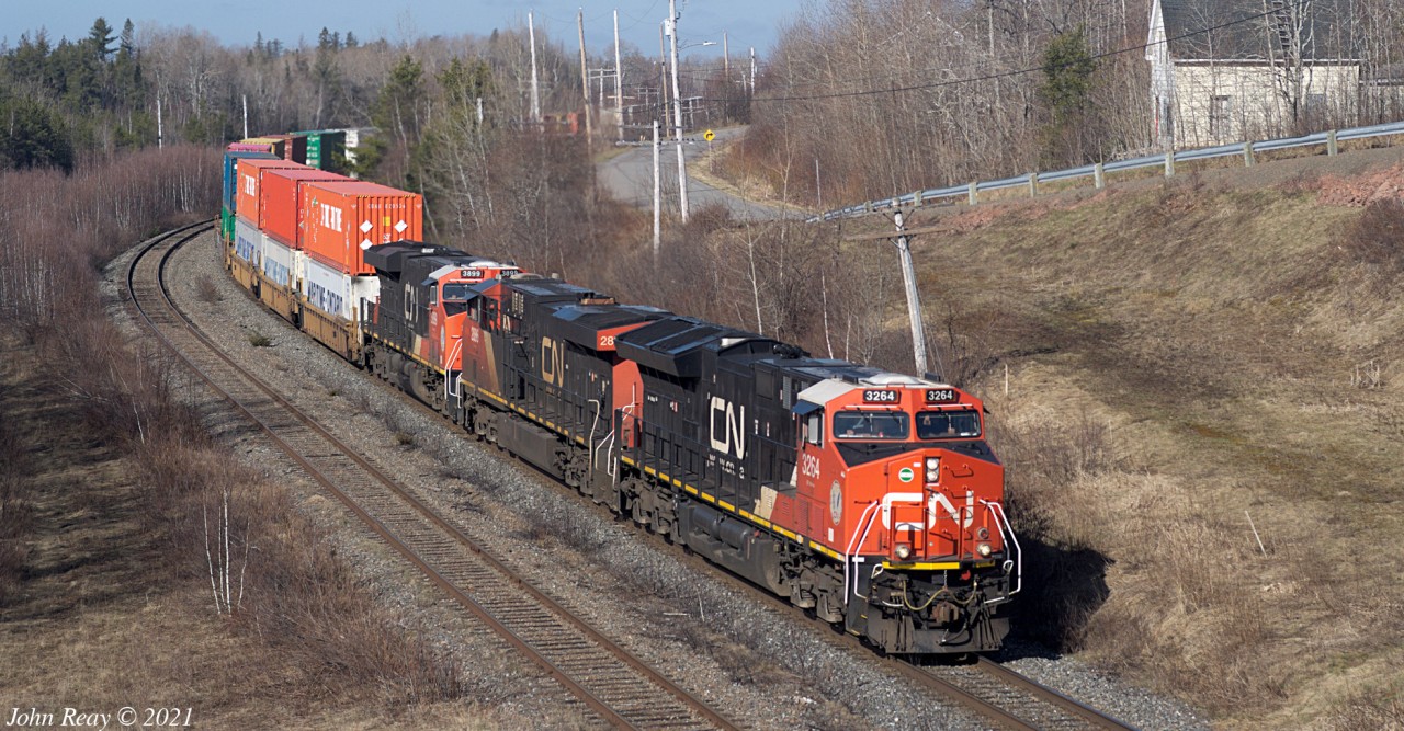 2021/04/15 09:38 CN train 120 (daily Toronto-Halifax intermodal) rounds the curve approaching the Hwy 2 overpass.