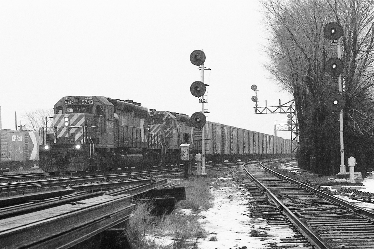 In the light snow


    two SD40's at Leaside Junction,


   CP Rail SD40-2  # 5749  west with SD40 #5539, have grain empties in tow


   on the left mile is 0.2 North Toronto Sub, on the right is the Don Branch mile 206.4 Belleville Sub.,


   note the  'return-to-train'  push buttons near the base of each signal mast to allow crews to have a 'restricting' signal for each route ( to accommodate 'the push' engine(s) ).


   the phone in the phone box at the base of the 0.2 mile signal mast is active.


   And at the near right was the newly lifted siding switch into the Caterpillar dealership


   and jointed rail everywhere !


   at Leaside Junction, Kodak Tri X negative, December 22, 1979 by S.Danko