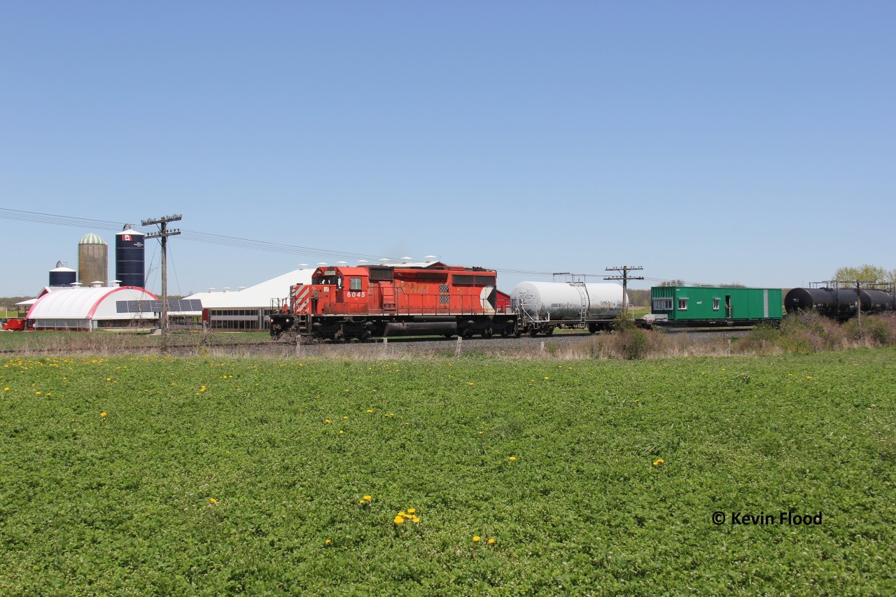 The 2020 Weed Spraying Train is underway again, passing a farm, after holding just east of this crossing due to a track block at the Mile 94.86 Galt Sub crossing (Zorra Station). The 2021 train featured an SD40-2 as well (No. 6043); however, this engine was in much better shape with a multimark to boot.
