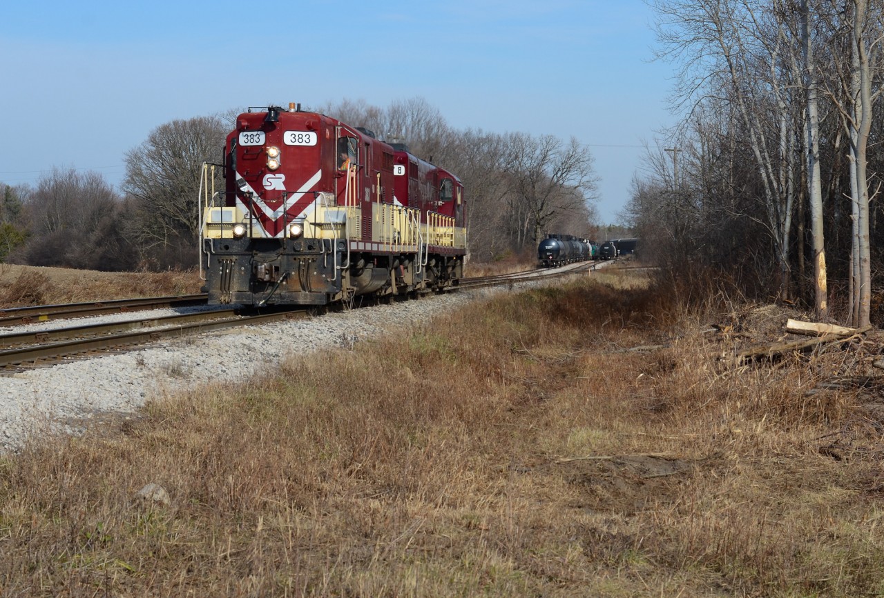 Propane season on the OSR - After just coming up from Tillsonburg, The St Thomas Job with the GP7’s have just cut their train preparing to make a lift at “Thomas Road” while the Woodstock Job pulls racks out of CAMI in the background. After the lift, the former SOO high hoods will then head to St Thomas for another day of switching propane and other customers under a sunny sky. Always great to hear motors built in the 50’s still doing work 70 years later.