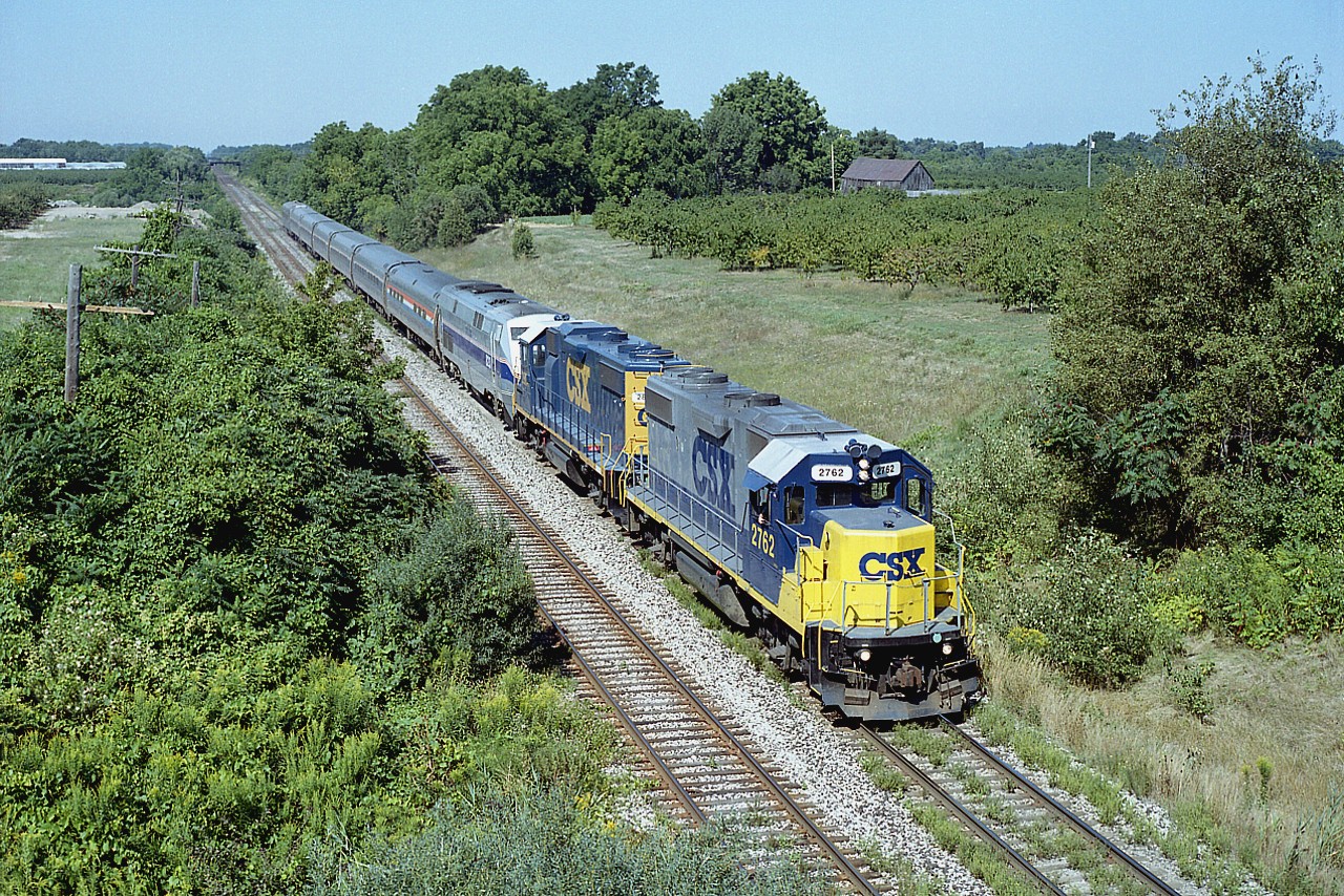 Because it is the rural countryside, I like to call this location, looking west off the Seventh Av Louth bridge, by the name of Lincoln, although I am actually standing inside the city of St. Catharines limits. The boundary is just behind the train.
Anyway, seeing these two CSX units leading Amtrak the night before as it was Toronto bound was something of a shock. And I had high hopes the same combo would come back the next day, and it did.
At the time, I was working. Or rather, scheduled, but we happened to have gone on strike and I was walking the line.
Near train time, I took a few orders for coffee and off I went. Picked up the train in Hamilton and followed it down to St. Catharines station; grabbing a few pics on the way. It was nearly 3 hours by the time I got back to the lines with the coffee. It was hot, I bought it right around the corner from where I was working, on the way back.
The only people that missed me were the ones waiting patiently for coffee. I will admit they were concerned. But it was a great morning out, and so here is CSX 2762, 2804, Amtrak 823 as #97. Never did find out what the problem with the AMTK unit was, but I certainly enjoyed the time away from the misery of a picket line.