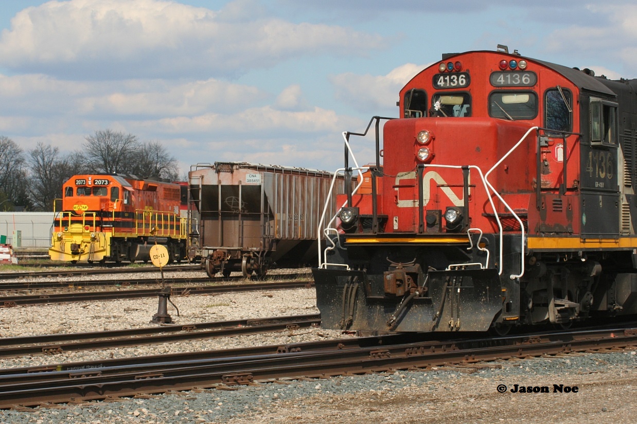 CN L568 is viewed setting-off in the Stratford yard with 4136, 4125, 7083 and 4790. In the background, the power for Goderich-Exeter Railway 581 awaits their next work day.