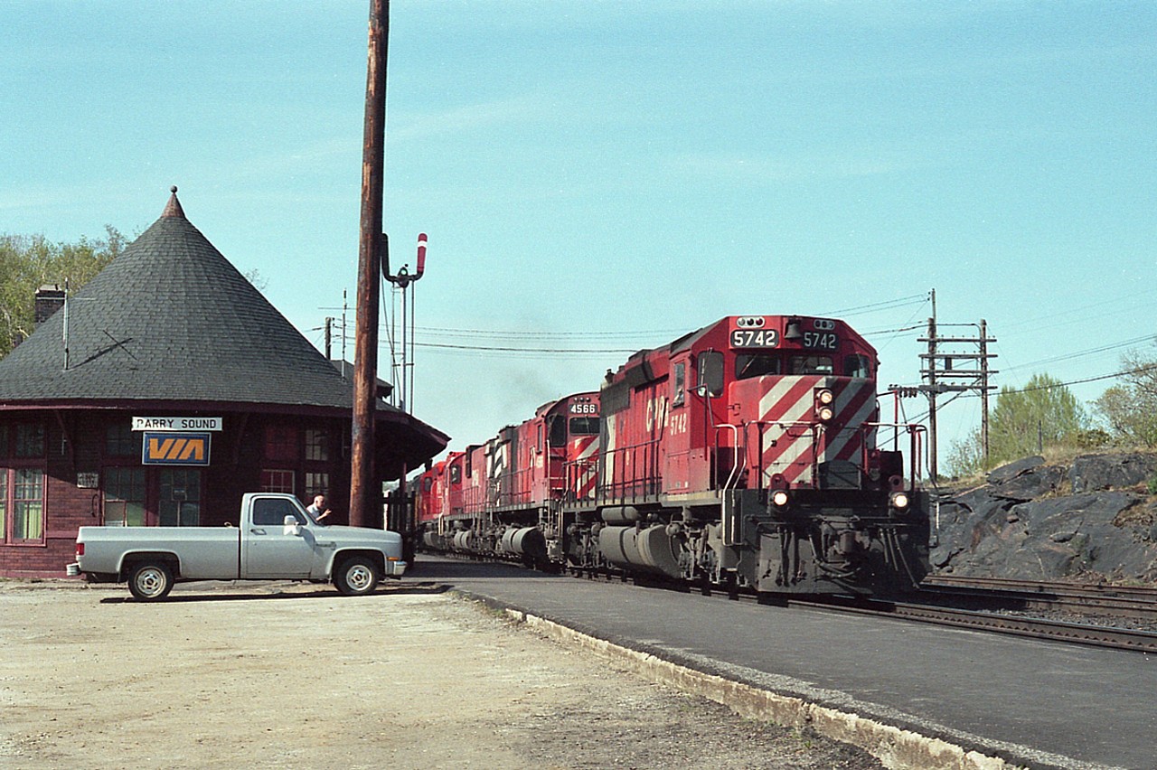 Southbound (read: eastward) CP freight moving smartly along as operator Jimmie Bell, by the side of his truck, keeps an eye on its passing.  This train moved along so quick, coupled with the fact my pen did not want to write, resulted in my failure to get all the engine numbers. Recorded are: CP 5742, 4556, 4xxx,xxxx, Chessie xx30 and CR 7763. The lead unit was one of two (the other being 5745) that was later graced with the words "eXpressway" on the flanks, but not much came out of that.
That communications tower sure put a monkey wrench into my ability to get better images around that station.