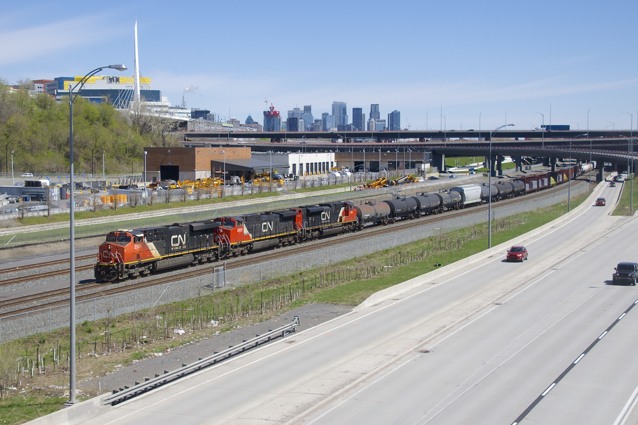 CN 2301, CN 2620 & CN 8955 are the power on a 103-car CN 321 as it passes the skyline of downtown Montrea