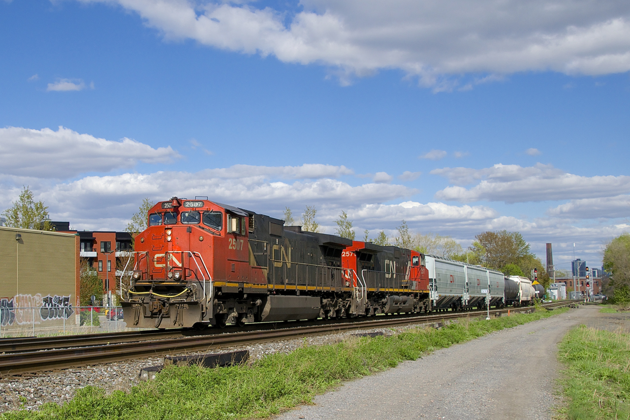The clouds part just as a 7-car CN 323 passes with two Dash9 variants for power (CN 2507 & CN 2571).