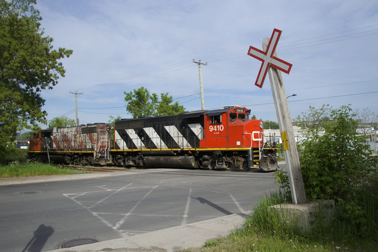 After setting off one car in the siding, CN 9410 & CN 4774 are heading back east so they can throw a switch and go grab a car from the Kruger plant. On the scanner. the crew could be heard talking about how this crossing of Monk Boulevard (which they have to manually flag) is the most dangerous one in the territory.