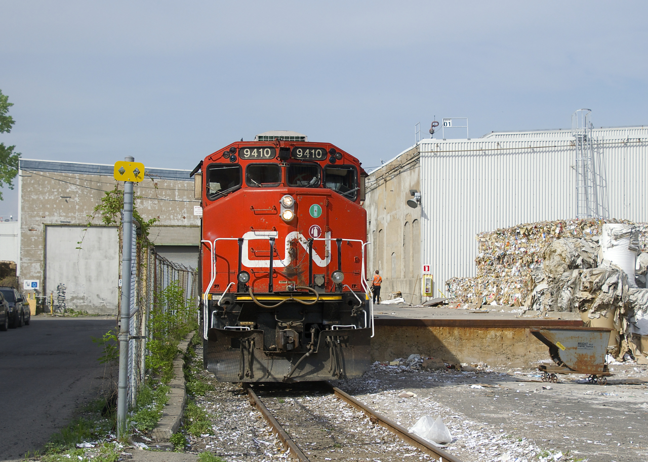 The Pointe St-Charles switcher is setting off boxcars at the Kruger recycling plant, located at the end of the short Turcot Holding Spur. The conductor can be seen walking back so he can inspect the cars to make sure that they are properly secured and that their are no objects stuck between the cars and the dock.