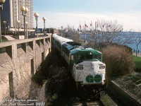 <b>GO trains in Sarnia?</b> The new CN St. Clair Tunnel opening between Sarnia and Port Huron on May 5th 1995 featured a few special events held on May 5-7th to celebrate this cross-border rail connection under the St. Clair River. According to a 1995 issue of Branchline, a few special trains were run from Toronto and the US to the event. VIA and GO Transit equipment was borrowed for some of those specials, and another GO consist was used as a shuttle train giving rides through the tunnel for the event (there were some customs checks needed for riders). Officials and dignitaries had their event on Friday the 5th, on the 6th was for employees, and the 7th was for the general public. <br><br> On May 6th, the employee event, three special trains were run to Sarnia's Centennial Park on the waterfront (via the Point Edward Spur) for the opening day events. Two consists ran from Toronto (VIA F40's and LRC cars for one, and a double-ended GO consist for the other) and a special from the US with GTW and Amtrak equipment all headed down the Point Edward Spur, where they laid over near the park, from which they would depart from at the end of the celebrations. Shown here, GO F59PH 524 passes by the First Sarnia Place parking garage on the waterfront at Front & Lochiel, as it brings up the rear end of one of the employee specials from Toronto, an L7L consist with 524 on one end and 544 leading on the other. It's likely the end of the day and the train is returning back to the mainline to return to Toronto after the end of celebrations. The GO tunnel shuttle ran with different borrowed GO equipment through the tunnel (568 at one end and a cab car at the other). <br><br> <i>Gord Taylor photo, Dan Dell'Unto collection slide</i>.