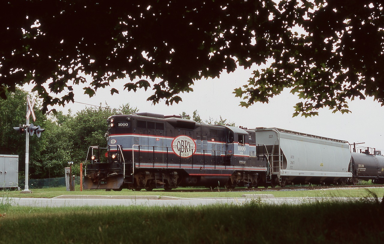 A true veteran, OBRY 1000 changed little from the day it rolled off the assembly line other than fresh paint as it moved from owner to owner. It was the OBRY's first unit and only one to carry the railroads name, the rest would wear full Cando paint. After several years of service along the line to Orangeville it was eventually bumped by rebuilt GP9RM's and sent to another Cando operation. Sadly a couple years ago it was returned to Manitoba and scrapped. The sight of a leased MP15 on today's OBRY just doesn't have the same affect these days as these old Geeps. This day 1000 had just finished working the CP interchange and was on the move northward after a quick coffee stop at a local Tim Hortons.