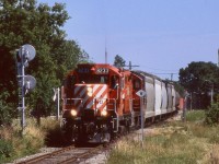 One of my few catches of CP's late afternoon "Moonlight" to Orangeville late in the trains existence. Sadly by tis time the old CP station here was moved to a piece of farm land and rotting away. The train and its two GP9U's have just been given the light to cross CN's busy Halton sub. Luckily the late day running of this train provided much better northbound lighting than today's OBRY operations do. It appears this line will fall silent by years end, but hopefully its future will somehow improve, after all the old station that sat here rase amazingly resurrected and is now a part of Mount Pleasant's community centre in Northeast Brammpton.