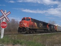 CN 3111 and CN 3898 lead train A407 at a rural grade crossing on Claremont Road between Salt Springs and Oxford Junction on the CN Springhill sub, at 14:34 on May 16th, 2021. Tri-levels immediately behind the power is a goog sign that on this day the train did not lift anything from the CB&CNS at Truro yard.