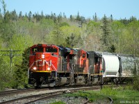 CN train 407 approaching Oxford Jct, MP 46.7 CN Springhill sub at 15:29 on May 24th, 2021, with the station sign in view. This train had 296 axles and three units (trailing unit is CN 4700, a conventional cab GP38-2, possibly heading to Moncton for service.)
