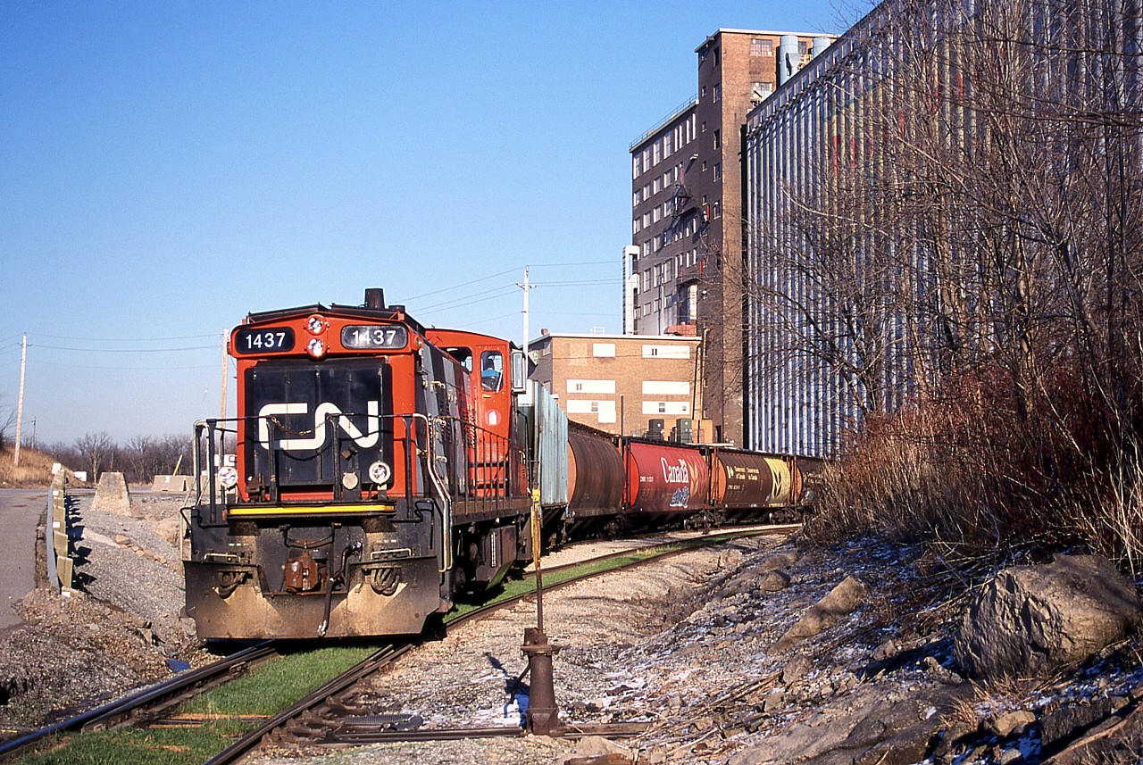 CN 1437 was recently purchased by the Waterloo Central Railway.  The GMD-1u was assigned a notable role in 2003, being leased to the power-short Port Colborne Harbour Railway.  It is seen here switching grain hoppers at the massive Robin Hood Flour elevator in Port Colborne.  This was the same day Dad and I photographed TRRY 110 on Townline Road (between St. Catharines and Thorold) on their way to switch Interlake Paper seen here:  http://railpictures.ca/?attachment_id=12045