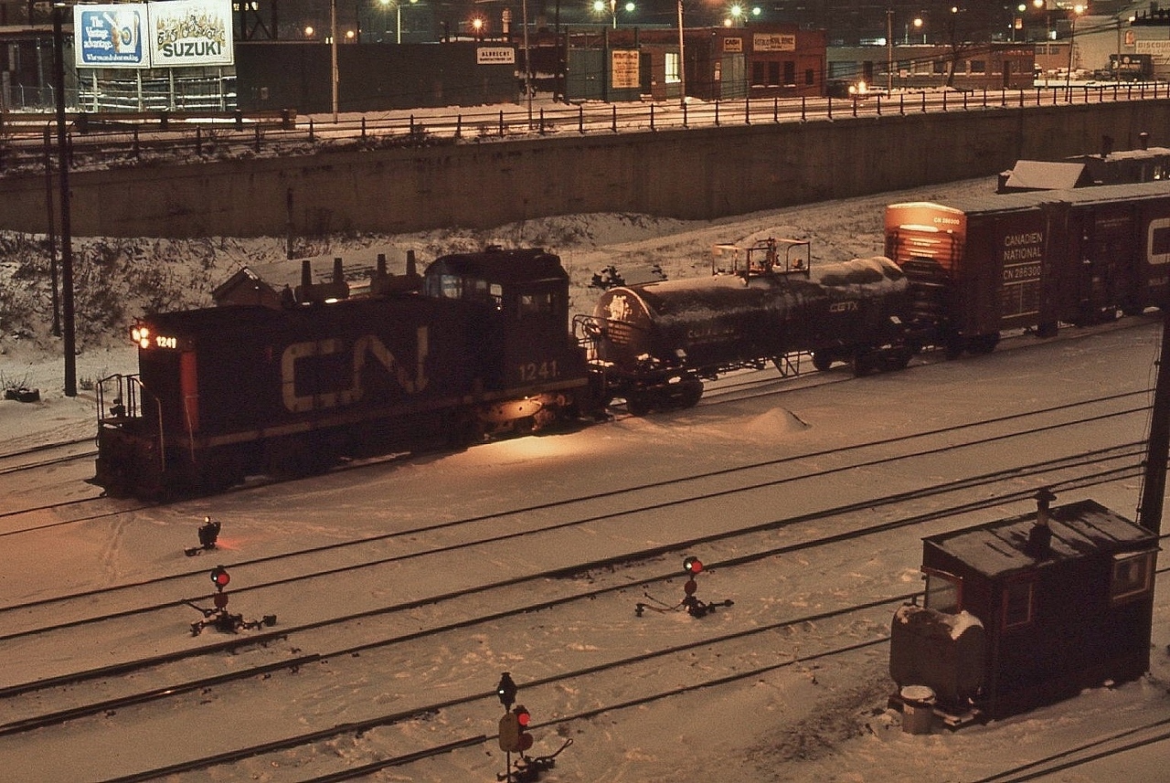 On a cold evening, GMD 1957 built SW1200RS  CN #1241 works the north yard beside Front Street

 
  at Bathurst Street, December 18, 1976 Kodachrome by S.Danko