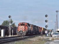 <br>
<br>
   Typical Sunday afternoon....the Fans gather...
<br>
<br>
   and a typical westbound mixed freight powered by two SD40-2's sandwiching two M636's ( 4706, 47??), and a  RS-18 trailing.... 
<br>
<br>
    CP Rail 5738 west is about to knock down the 'new' signal 2063-2
<br>
<br>
   At Leaside, September 30, 1984 Kodachrome by S.Danko
<br>
<br>
   Interesting: 
<br>
<br>
   that is the 'new' cross over ( westbound: south track to north track), with the new signal masts, all installed at the time the welded was rail laid down,
<br>
<br>
   when the ribbon rail was installed the original CPR Leaside centre passenger platform was removed,
<br>
<br>
   That platform on the near right was the location of the VIA kiosk that was removed after the Havelock Budd Car final run September 6, 1982. The Havelock Budd returned on June 3, 1985 and canceled January 1990.
<br>
<br>
   The fencing was installed at the time the Leaside Village Station Restaurant opened (1975), and after the restaurant closed (1983) the Leaside station was converted to the CP Rail Customer Service Centre for a short time. In 2009 the property was purchased by Metrolinx ( including the Don Branch) and today the building is vacant.
<br>
<br>
   sdfourty

