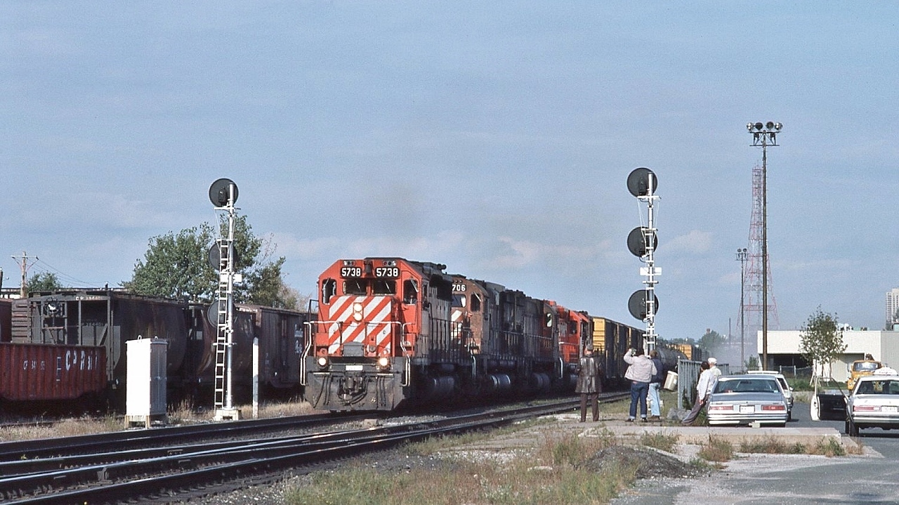 Typical Sunday afternoon....the Fans gather...


   and a typical westbound mixed freight powered by two SD40-2's sandwiching two M636's ( 4706, 47??), and a  RS-18 trailing.... 


    CP Rail 5738 west is about to knock down the 'new' signal 2063-2


   At Leaside, September 30, 1984 Kodachrome by S.Danko


   Interesting: 


   that is the 'new' cross over ( westbound: south track to north track), with the new signal masts, all installed at the time the welded was rail laid down,


   when the ribbon rail was installed the original CPR Leaside centre passenger platform was removed,


   That platform on the near right was the location of the VIA kiosk that was removed after the Havelock Budd Car final run September 6, 1982. The Havelock Budd returned on June 3, 1985 and canceled January 1990.


   The fencing was installed at the time the Leaside Village Station Restaurant opened (1975), and after the restaurant closed (1983) the Leaside station was converted to the CP Rail Customer Service Centre for a short time. In 2009 the property was purchased by Metrolinx ( including the Don Branch) and today the building is vacant.


   sdfourty