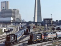 <br>
<br> 
  Busy Sunday afternoon at Spadina,
<br>
<br> 
  Entertainment provided the S-13's, a plenty...
<br>
<br> 
  CN 8518 pushing a string of blue coaches through the wash and another S-13 has a Tempo generator – baggage in tow...
<br>
<br> 
   and 8515 is working the AMTRAK F40PHR #280 with the Maple Leaf consist 
<br>
<br> 
  CN Spadina coach yard, September 30, 1984 Kodachrome by S.Danko
<br>
<br> 
   Noteworthy: from the right, in the coach yard, two more S-13's,  LRC cars, Tempo cars, in the distance Budd Cars, what appears to be a Track Inspection Car or Rail Grinder, a regular tail end feature of the seventies Super Continental: CN 'car-go-rail'  enclosed auto carrier, and the nearly new rail grade separation line.
<br>
<br> 
