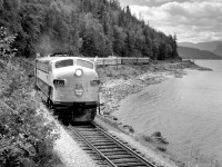 The centennial celebrations of the Province of B.C.'s becoming a Crown Colony in 1858 were marked by a visit of Princess Margaret to the Province.  Upon leaving Vancouver for Banff, the CPR provided the Princess with a 9 car special, including one dome & two business cars, which special train is seen here, July 29, 1958, on the shores of Shuswap Lake, 72 miles east of Kamloops.  Waiting behind spiked switches, all opposing passenger trains cleared X E 1433 by one hour, freight trains by 5 hours.
