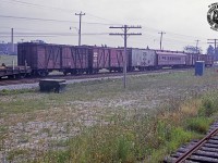 A block of work cars are seen occupying siding XV50 along the CN Fergus Sub, paralleling Edinburgh Road in Guelph.  These cars range from tool and storage cars to sleeping quarters, a crew diner, and various others.  The bit of orange just visible at left is part of a Jackson Multiple Tamper (thanks Paul O'Shell) numbered CN 650-15.  More equipment, including a ballast regulator, Burro crane 50418 and flatcars of crane attachments, and more sit out of frame, including a new ATCO portable mounted on a flatcar.<br><br>The track at lower right is the siding to Guelph Terminal Warehousing (XV32), now long removed.  At upper left the original <a href=https://s3.amazonaws.com/pastperfectonline/images/museum_460/037/08442.jpg>St. Joseph's Hospital</a> can be seen.  Opened in 1861, St. Joseph's Hospital on Westmount Road (originally Hospital Street) served the community until operations ceased about 2002, and the new St. Joseph's Health Centre opened on the property just to the north, as a long term care home.  A brief history of the site <a href=https://www.chac.ca/documents/171/Guelph_St._Josephs_Hospital_and_Home__a_short_history_1861-1986.pdf>can be found here.</a>
