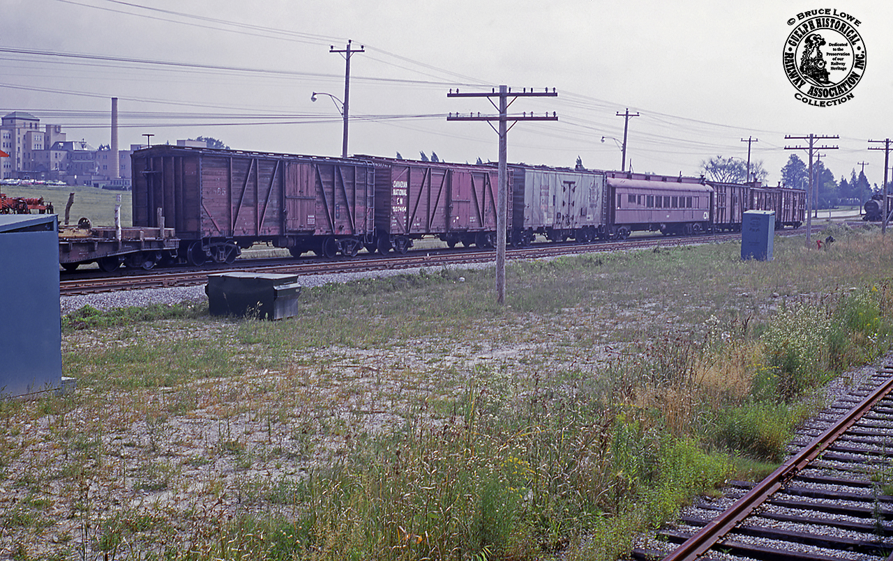 A block of work cars are seen occupying siding XV50 along the CN Fergus Sub, paralleling Edinburgh Road in Guelph.  These cars range from tool and storage cars to sleeping quarters, a crew diner, and various others.  The bit of orange just visible at left is part of a Jackson Multiple Tamper (thanks Paul O'Shell) numbered CN 650-15.  More equipment, including a ballast regulator, Burro crane 50418 and flatcars of crane attachments, and more sit out of frame, including a new ATCO portable mounted on a flatcar.The track at lower right is the siding to Guelph Terminal Warehousing (XV32), now long removed.  At upper left the original St. Joseph's Hospital can be seen.  Opened in 1861, St. Joseph's Hospital on Westmount Road (originally Hospital Street) served the community until operations ceased about 2002, and the new St. Joseph's Health Centre opened on the property just to the north, as a long term care home.  A brief history of the site can be found here.